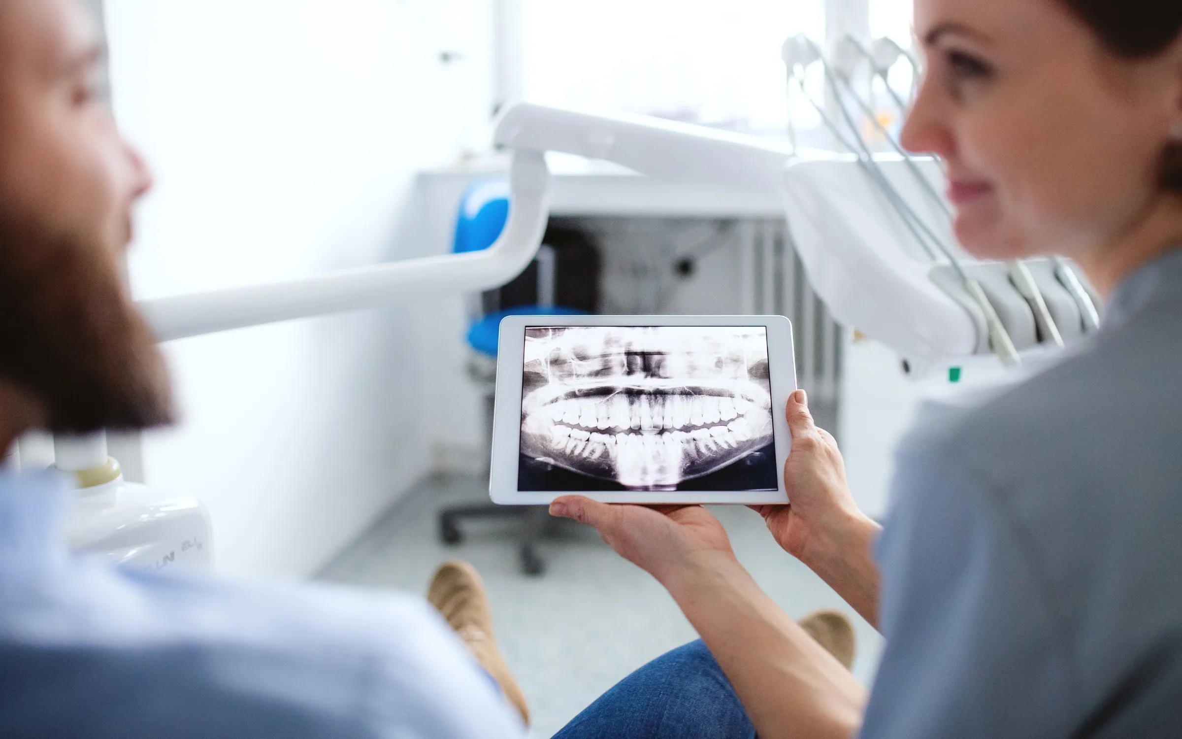 A dentist reviewing dental X-rays with a patient A dentist reviewing dental X-rays with a patient