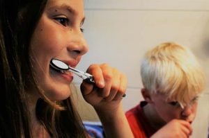 Children brushing their teeth for cavity prevention.